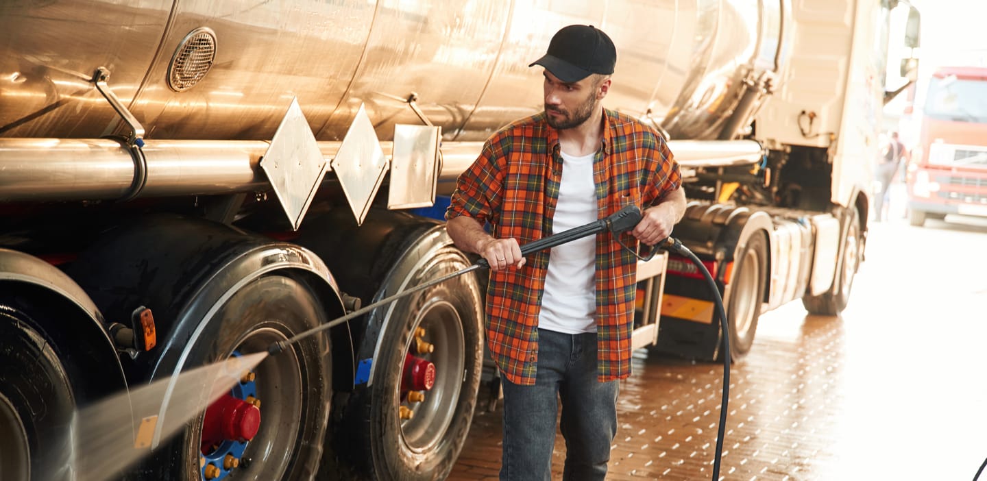 Man pressure washing a truck.